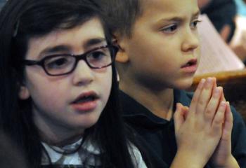 Ella Anastasian, left, and Jack Brady pray during the special Mass. 