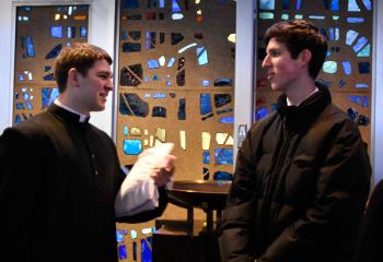 Seminarian Keaton Eidle, left, greets Matthew Schacte before the Mass. 