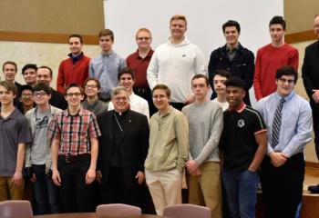 Bishop Schlert, front center, and Father Searles, back right, gather with the boys and seminarians. Several seminarians attended the Mass and reunion, a few of whom were campers at Quo Vadis.
