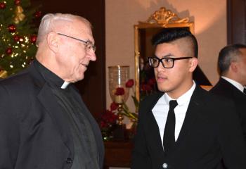 Monsignor John Grabish, left, and Anh Do Mai talk during the festive event.