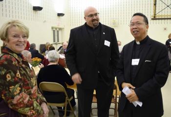 Father Achilles Ayaton, right, pastoral care of Health Care Facilities served by the Cathedral of St. Catherine of Siena, Allentown, and Father Stokes enjoy a conversation with Marie Mazzini.