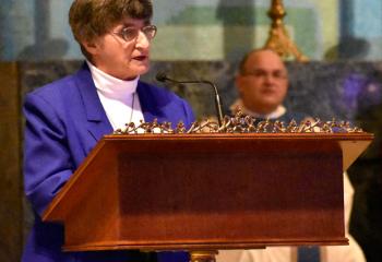 Monsignor Thomas Koons, back, listens as Sister Dorothy Fabritze offers the first reading.