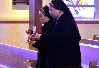Sisters Apostles of the Descent of the Holy Spirit Sister Mary Jerome Kim and Sister Mary Francesca Seo bring the offertory gifts to the altar.