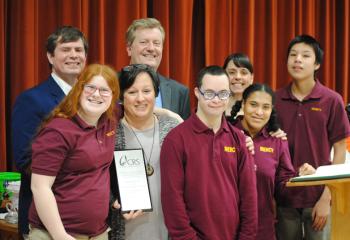 Beth Grys, front second from left, principal of Mercy School for Special Learning, Allentown, celebrates the award from CRS recognizing it as a platinum level school with students, and diocesan and CRS staff. Others are, from left: front, Summer Litchock; Abe Estremera; Jolie Sessoms; back, Jeff Wallace; Bob Olney; Brooke Tesche; and Tylee Esbensen.