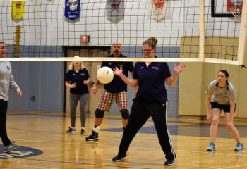 A staff member from St. Ignatius Loyola Regional School misses the ball during a volleyball set against students. (Photo by John Simitz)