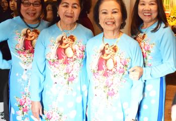 Women donning Vietnamese dress with the image of the Blessed Mother and Christ child are, from left, Hanh Ngo, Xuan Nguyen, Ly Tran and Hien Pham.