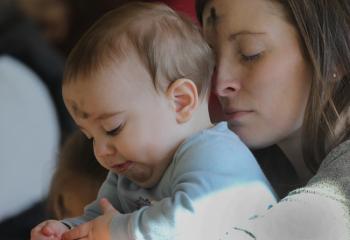 A mother holds her baby during Ash Wednesday Mass at Jesus the Divine Word Church in Huntingtown, Md., March 6, 2019.  (CNS photo/Bob Roller)