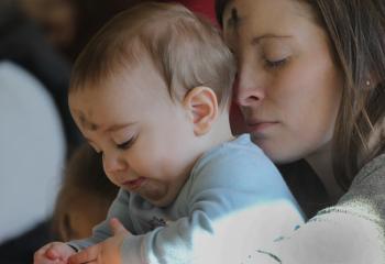 A mother holds her baby during Ash Wednesday Mass at Jesus the Divine Word Church in Huntingtown, Md., March 6, 2019.  (CNS photo/Bob Roller)