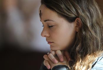 A young woman prays during Ash Wednesday Mass at Jesus the Divine Word Church in Huntingtown, Md., March 6, 2019. (CNS photo/Bob Roller)