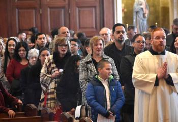 Father Mark Searles, director of the Office for Vocation Promotions, leads catechumens and sponsors during the processional at the cathedral.