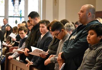 Catechumens join together in prayer during the Rite of Election.