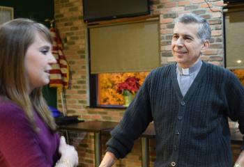 Alexa Smith, left, director of the Office of Youth, Young Adult and Family Ministry, chats with Deacon Bellitto during Theology on Tap at the Hops at the Paddock, Allentown.