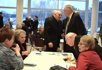 Father Alex Pocetto, left, retired vice president of the Division of Liberal Arts and Social Sciences at DeSales, mingles with gala guests.