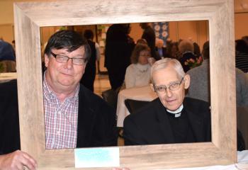 Mike Bauman, parishioner of Most Blessed Sacrament, Bally, left, and Monsignor Walter Scheaffer, pastor of St. Mary Kutztown, have their photos taken with the “Because We Are Catholic” picture frame.