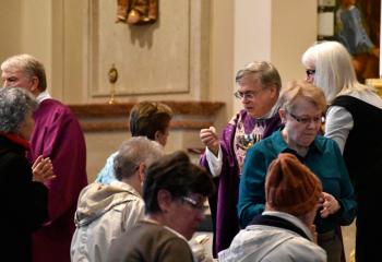 Bishop Schlert distributes Communion with Deacon Robert Snyder at left.