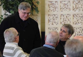 Bishop Alfred Schlert, left, speaks with a group of men at the workshop including, at right, Mike Tully, vice chair of the Diocesan Commission for Men.