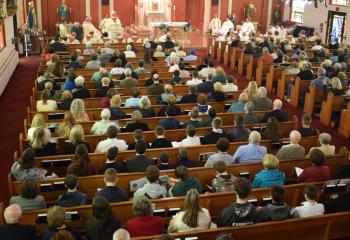Hundreds of faithful listen to Bishop Schlert talk about the life of the patron saint of parish priests. (Photo by John Simitz)