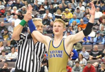 Ryan Crookham (40-2) of Notre Dame has his arms raised after winning the 120-pound state title in Class AA with a 3-0 victory. The Crusader frosh defeated last years’ state champion, senior Beau Bayless (39-8) of Reynolds. It was the second time Crookham beat his finals opponent as he whipped him 8-1 a few weeks earlier in the state team tournament. 