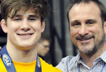 Luca Frinzi (38-10) of Bethlehem Catholic, left, finished fourth at 160 in the Class AAA state wrestling tourney. He is joined after his final high school match by his father, Scott, a Becahi assistant coach, near the wrestling prep area at the Giant Center. 