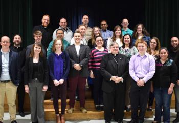 Bishop Schlert, center, gathers with young adults including: front second from left, Alexa Smith; middle left, Father Isaac and Rick Dooley; and back left, Father Mark Searles.