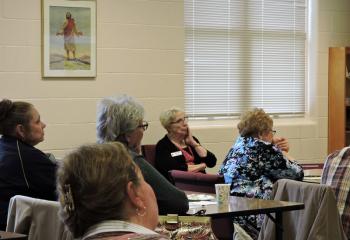 Sister of Mercy (RSM) Janice Marie Johnson, seated by window, ponders a point made by McKenty. (Photo by Tami Quigley)