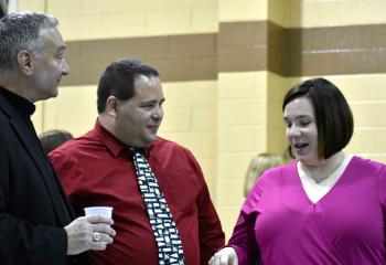 Monsignor Edward Zemanik, left, chats with Angle and Joe Zawisza, parishioners of St. Ambrose.