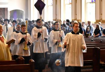 The faithful watch the procession during the Chrism Mass, celebrated at 10:30 a.m. at the Cathedral. The Mass manifests the unity of priests with the Bishop and calls for priests to renew their commitment to serve Christ and his Church by professing the promises they made at their ordinations to the priesthood.(Photo by John Simitz)