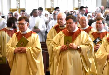 Father Robert Potts, pastor of St. Ursula, Fountain Hill, front left and Father Martin Kern, pastor of St. Columbkill, Boyertown, front right, are among the priests processing at the Chrism Mass.(Photo by John Simitz)