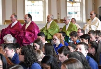 Deacons from the Diocese process in with the sacred oils for Bishop Schlert to bless for the faithful of the Diocese.