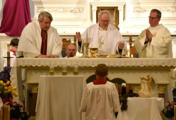 Monsignor William Baker, pastor of All Saints, McAdoo, center, celebrates the Mass of the Lord’s Supper on Holy Thursday April 18. Concelebrating are, from left: Father Thomas Cappelloni of Hazleton, a retired priest of the Diocese of Scranton who helps out at All Saints; and Monsignor Andrew Baker, brother of Monsignor William Baker, a priest of the Diocese of Allentown and rector of Mount St. Mary’s Seminary, Emmitsburg, Maryland. (Photo by John Simitz)