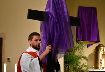 Father Ganser unveils the cross at St. Joseph. “Today, we feel sadness because of Christ’s Passion, but we turn to Mary so we can be comforted and strengthened by her motherly care,” said Bishop Alfred Schlert. (Photo by John Simitz)