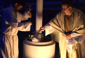 Father Eric Gruber lights the incense at St. John Fisher. (Photo by John Simitz)
