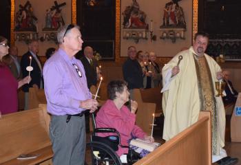 Father Eric Gruber blesses the faithful at St. John Fisher. (Photo by John Simitz)