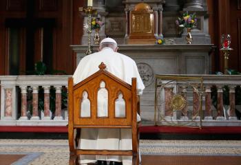 Pope Francis prays in front of a candle in memory of victims of sexual abuse as he visits St. Mary's Pro-Cathedral in Dublin Aug. 25, 2018. Pope Francis has revised and clarified norms and procedures for holding bishops and religious superiors accountable in protecting minors as well as in protecting members of religious orders and seminarians from abuse. (CNS photo/Paul Haring)