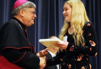 Bishop of Allentown Alfred Schlert, left, presents Bryleigh Reddy with her scholar award to attend Bethlehem Catholic High School. 