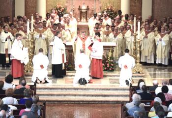 Bishop Schlert and clergy pray over the newly ordained men. (Photo by John Simitz.)
