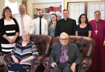 Father Wehr, back and third from right, meets with his family and Bishop Schlert, back and right, before the ceremony. Front, from left are: Linda Wehr, grandmother; and Paul Mikulcik, grandfather; back; Melissa Wehr; Dennis Wehr, father; Brandon Stelzman; Emily Wehr, sister; and Kathleen Wehr, mother. (Photo by John Simitz.)