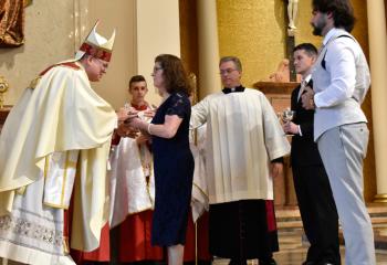Kathleen Wehr, right, presents the offertory gifts to Bishop Schlert, left. (Photo by John Simitz.)