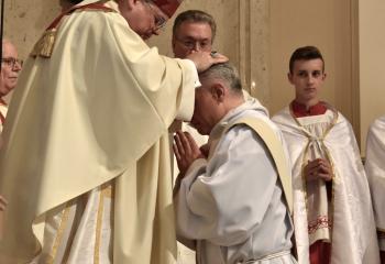 Bishop Schlert, left, ordains Father Maria to the priesthood during the Laying on of Hands. (Photo by John Simitz.)