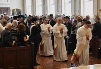 Candidates for the priesthood enter the sanctuary to commence the Rite of Ordination. (Photo by John Simitz.)