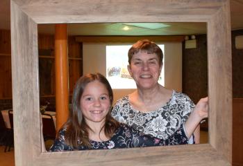 Andi Girard, left, and Anne Girard, parishioners of St. Joseph, have their photo taken with the portable photo frame.