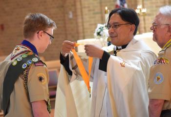 Josh L receives the Pope Pius XII award from Father Eric Tolentino and Bernard Hofmann.