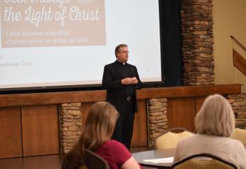 Monsignor Victor Finelli welcomes the approximately 25 adults gathered.