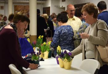 Mary Frances Fuehrer, left, and Betty Keating select their gift of a spring flower during the time of fellowship.