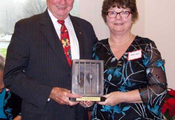 Robin Ball, right, presents Mike Ehlerman, benefactor of Clare of Assisi House, with Clare of Assisi House’s Spirit of Giving Award during the 2018 Holiday Brunch.