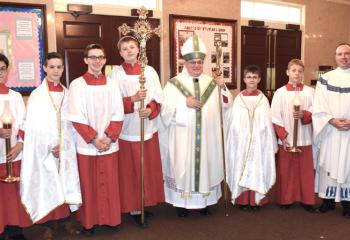 Bishop Schlert, center, and Father Christopher Butera, right, gather with altar servers before the Mass, from left, Theodore Spear, Liam Damitz, Gerard Behe, Jack Wert, Joseph Toelsch and Blaise Eidle.
