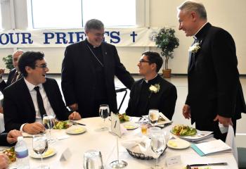 Bishop of Allentown Alfred Schlert, second from left, talks with, from left, a diocesan seminarian, Father Esposito and Father Maria during the dinner.