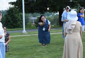 Sister Lisa Valentini tosses a water balloon to her partner during one of the games during Fiat Days.