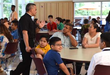 Deacon Juan Rodriquez, left, chats with parents during the opening of Quo Vadis and Fiat Days.
