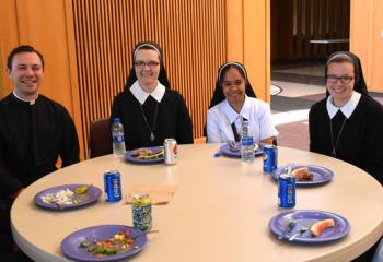 Diocesan seminarians and women religious, volunteers at Quo Vadis and Fiat Days July 14-18, enjoy a meal together.